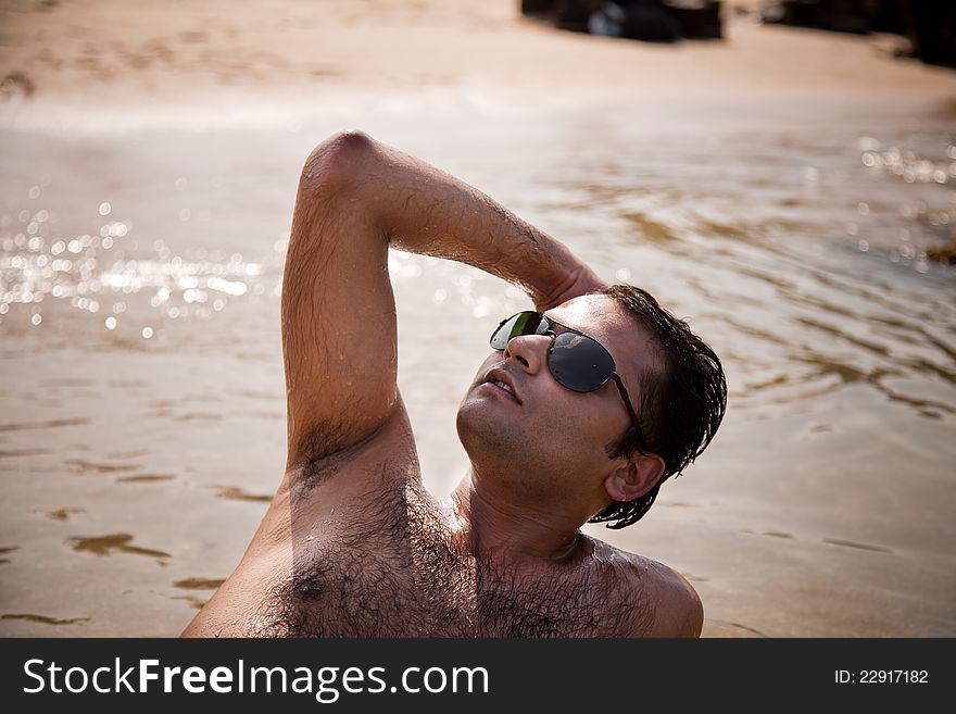 Indian man swimming at ocean beach