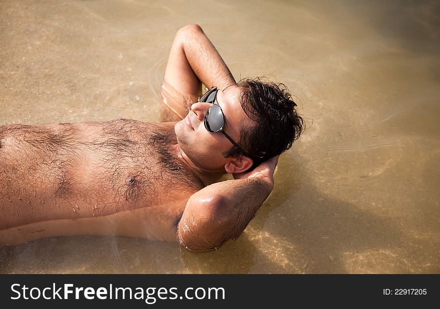 Indian man swimming at ocean beach