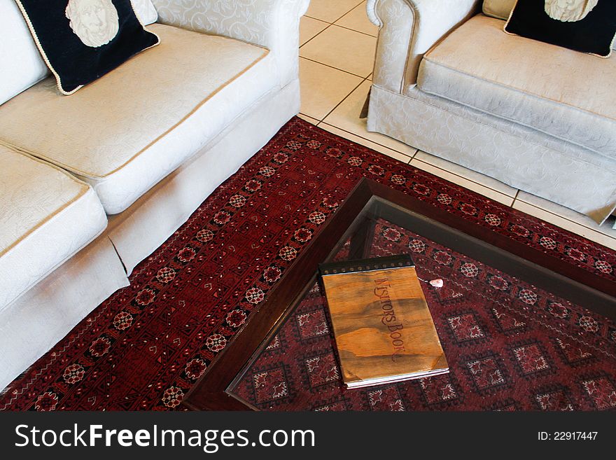 White couches with persian rug and a book on coffee table. White couches with persian rug and a book on coffee table