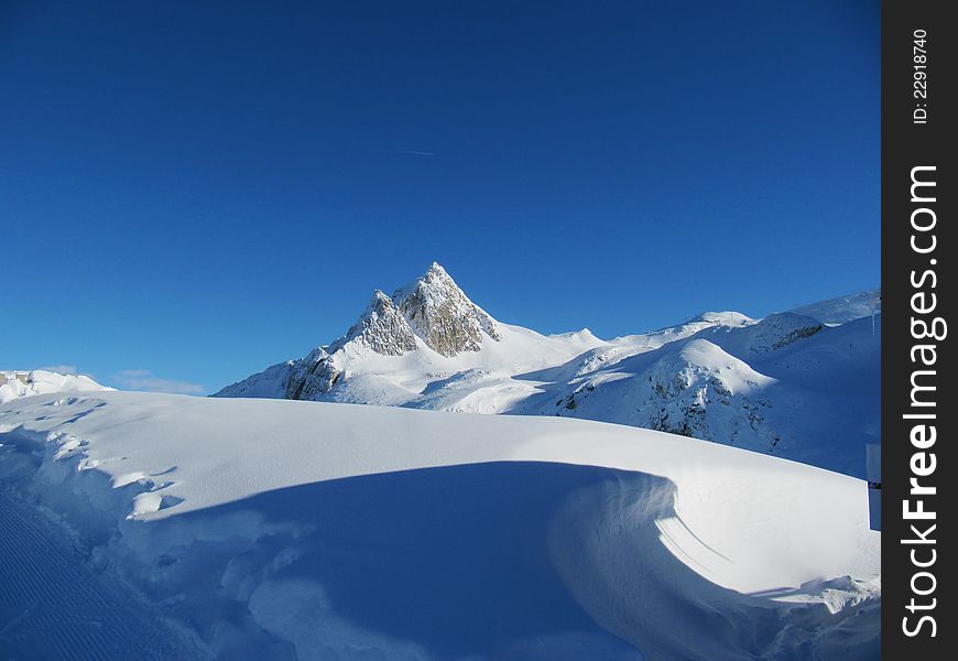 A snow covered alpine mountain. A snow covered alpine mountain