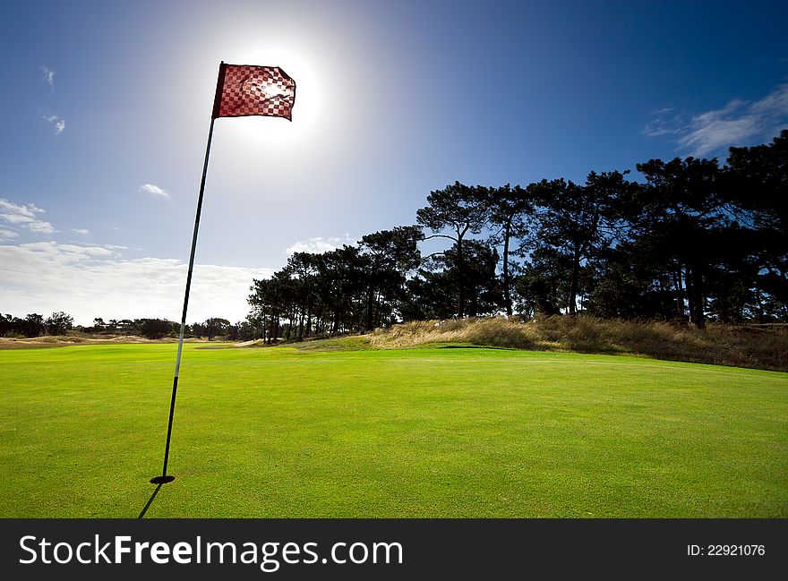 Sun shines behind a golf flag. Sun shines behind a golf flag