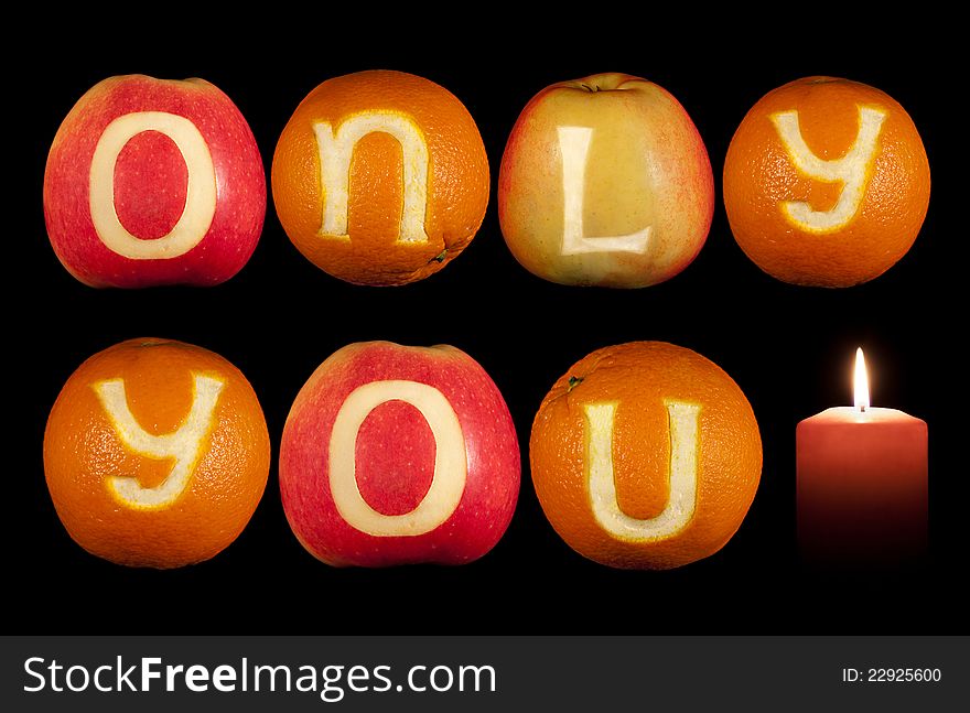 Words ONLY YOU carved on oranges and apples isolated on black. Words ONLY YOU carved on oranges and apples isolated on black