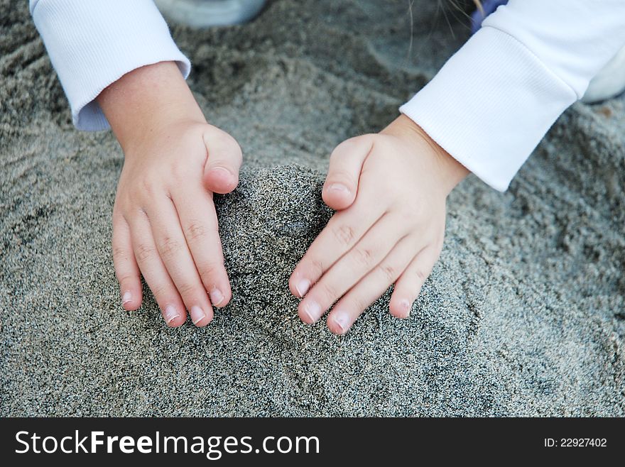 Kid building a tower with a sand