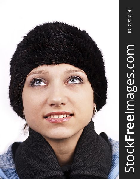 Young smiling woman in cap looking up on white background