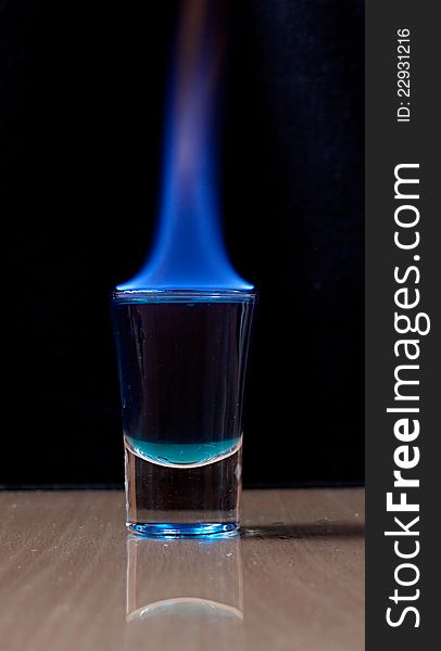 Burning drink in shot glass on a table