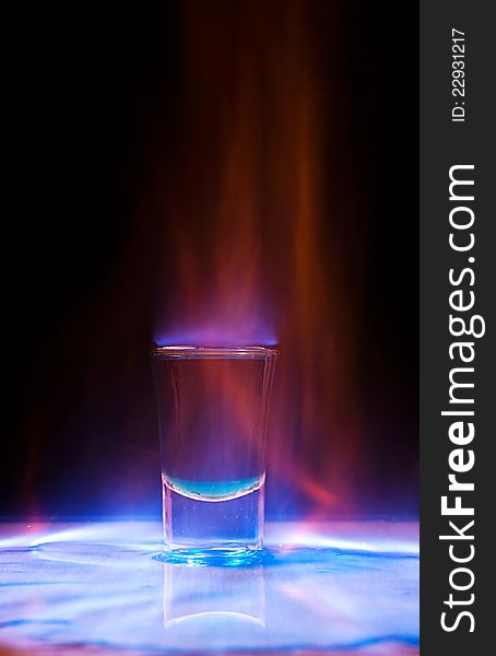 Burning drink in shot glass on a table