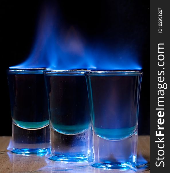 Burning drink in shot glass on a table