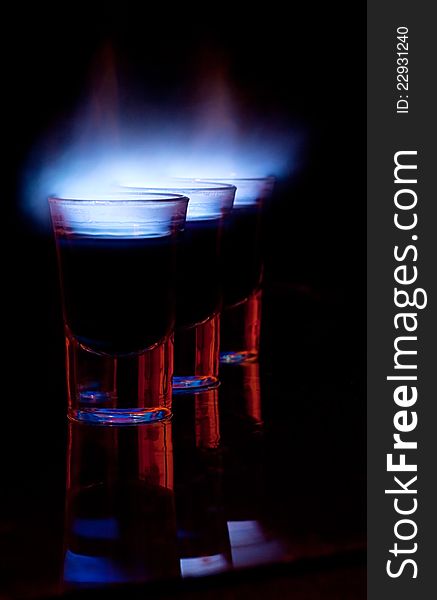 Burning drink in shot glass on a table