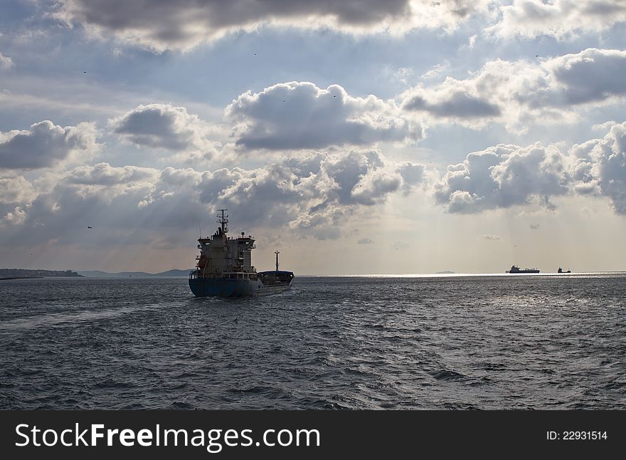 Cargo ship sails away in a cloudy day