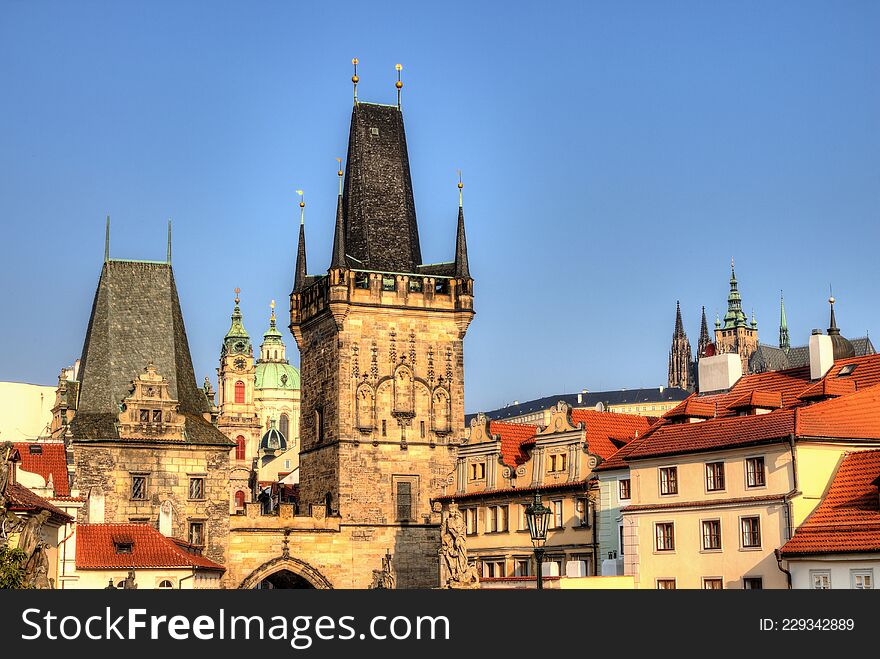 Malostranska district of Prague and the St Nicholas church, Prague towers lit by morning yellow sun. Malostranska district of Prague and the St Nicholas church, Prague towers lit by morning yellow sun