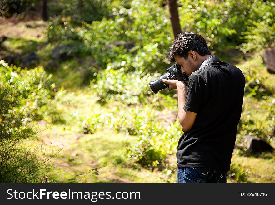 Indian young photographer taking some shoot in natural place