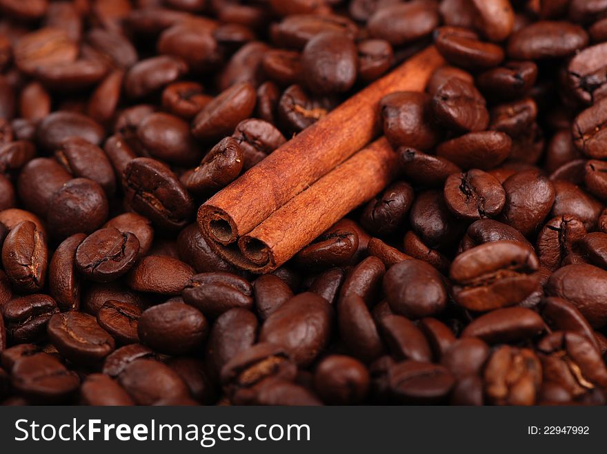 Macro photo of cinnamon sticks over coffee beans background. Macro photo of cinnamon sticks over coffee beans background