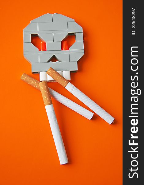 Skull and three cigarettes on orange. Skull and three cigarettes on orange