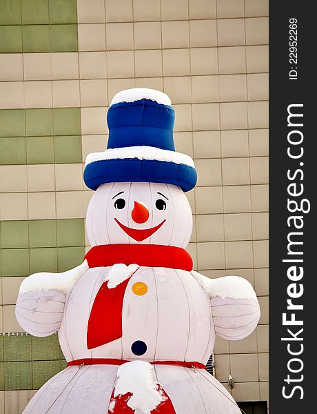 Snowman in a city court on the eve of New Year