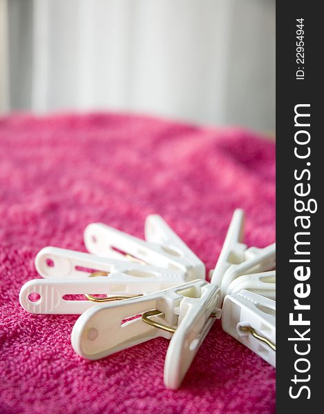 White clothes pins put on pink towel