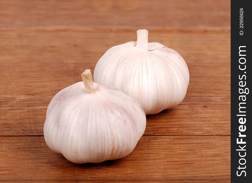 Image of two garlics over wooden background on food and drink theme concept