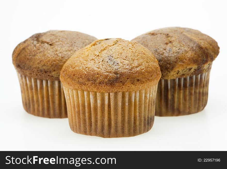 Three brown paper baskets of muffins. Three brown paper baskets of muffins