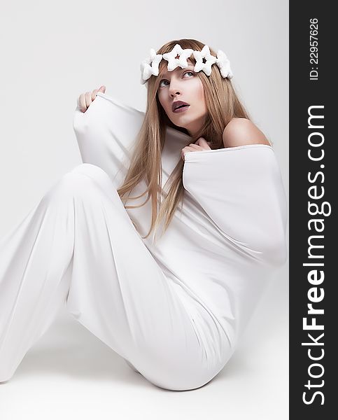 Dramatic theatrical pose - young girl actress in white crown and clothes sitting. Series of photos. Dramatic theatrical pose - young girl actress in white crown and clothes sitting. Series of photos