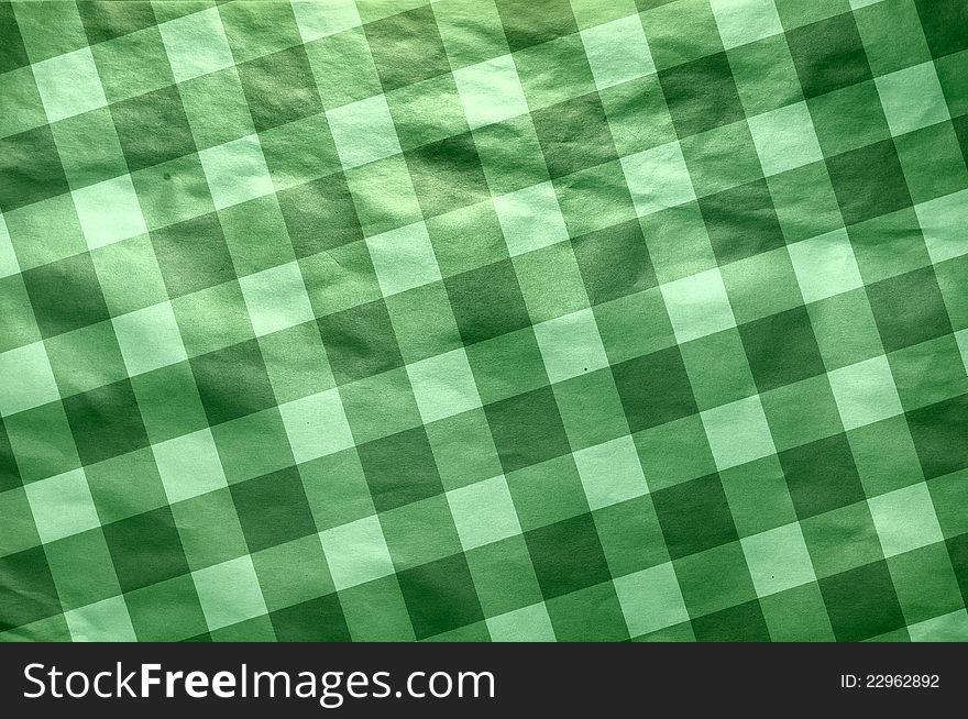 It is a texture of an old paper in green  cell. A background in style of a retro. It is a texture of an old paper in green  cell. A background in style of a retro