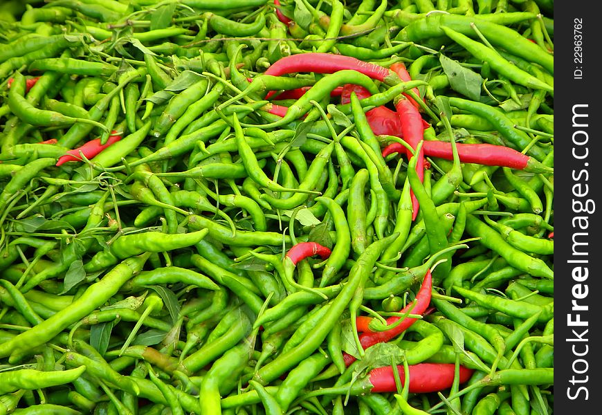 Pile of green and red hot chilli peppers