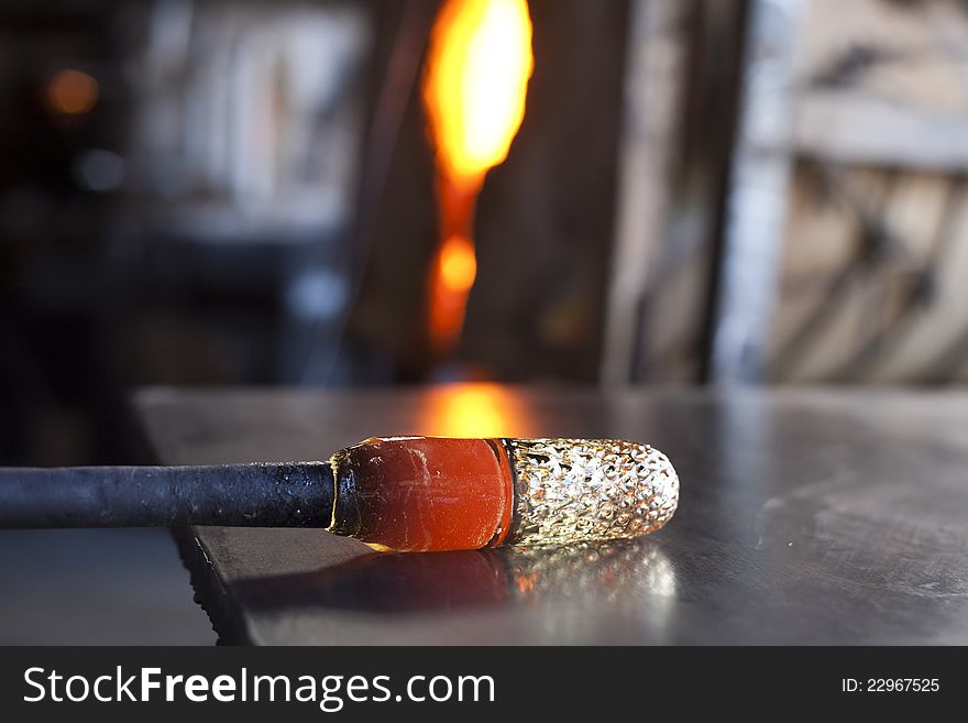 Glassblower shaping molten glass into a drinking goblet