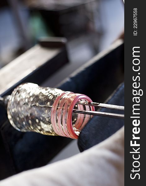 Glassblower shaping molten glass into a drinking goblet