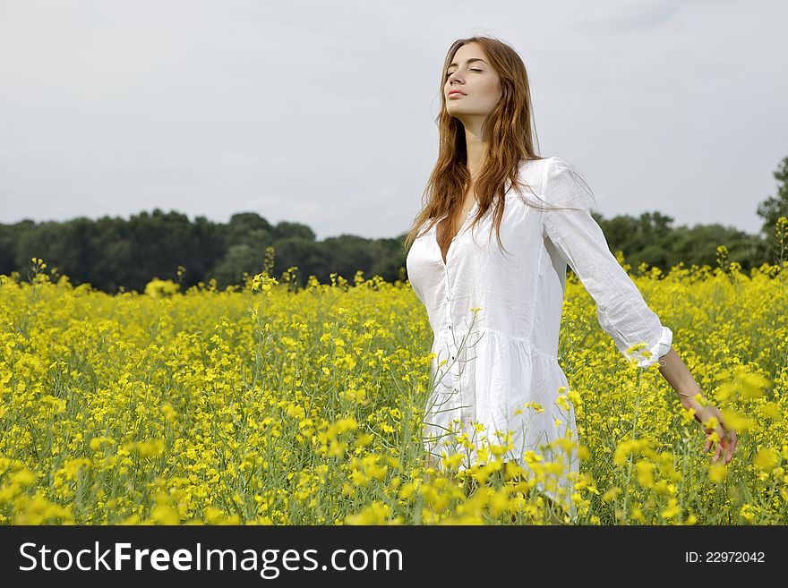 Brunette woman in a yellow flowers field