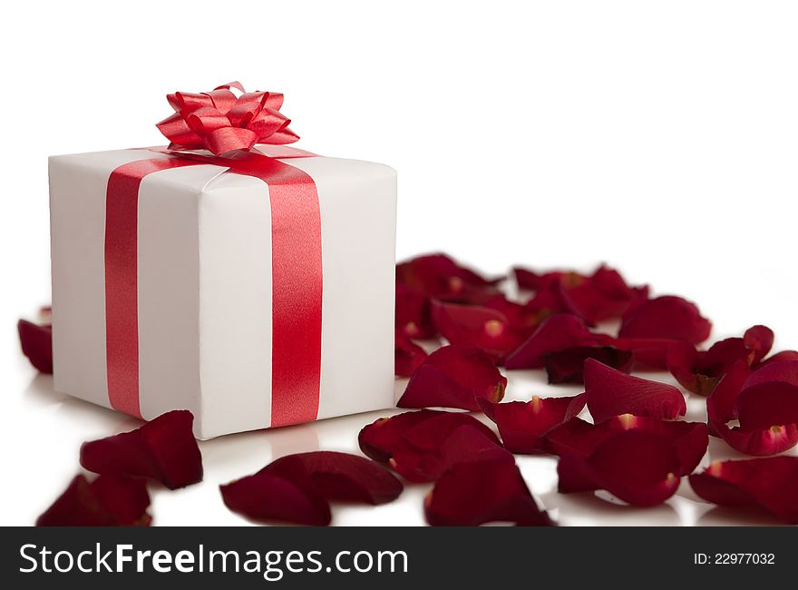 Gift box, rose petals on white background.