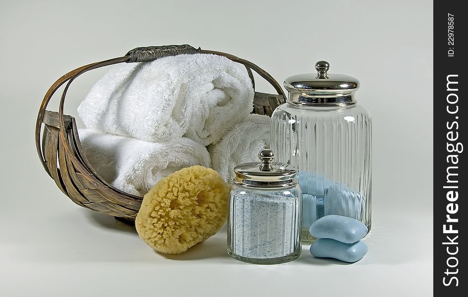 Items used in a luxurious bath, soft towels, scented soap, bath salts, and a sponge. Items used in a luxurious bath, soft towels, scented soap, bath salts, and a sponge