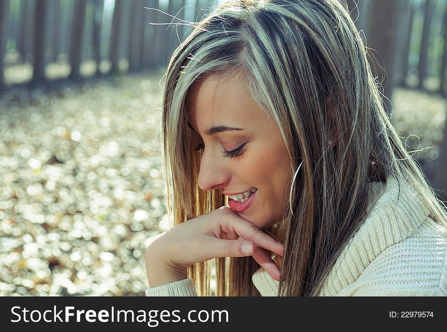 Beautiful blonde girl smiling in the woods