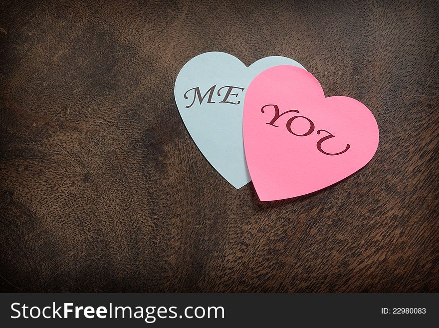Heart shaped post its on wooden background