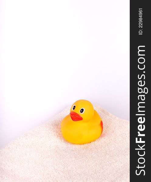 Rubber duck on white towel on white