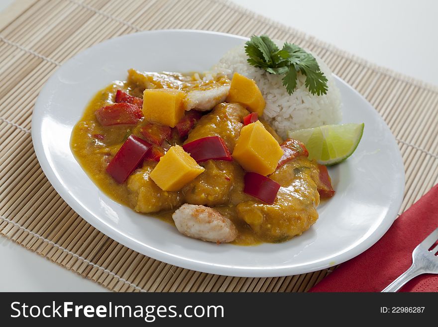 Spicy Thai mango chicken with red peppers, rice and lime