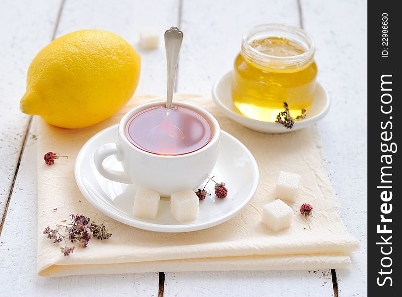 Tea with lemon and honey on a white background