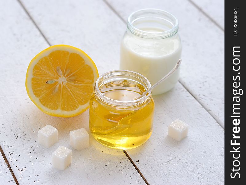 Honey, milk and lemon on a white background