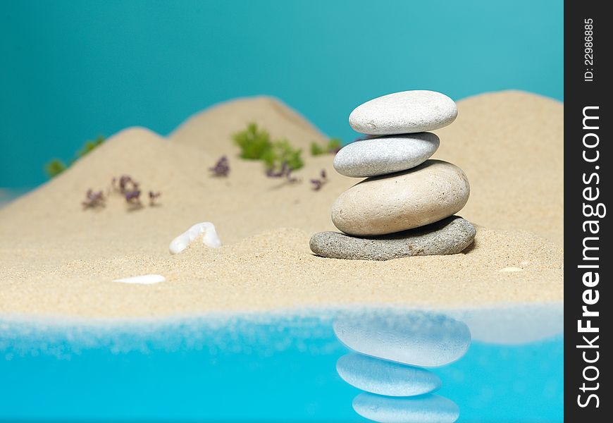 Zen therapy stone tower, on a sea shore miniature landscape, with reflexions in the sea. Zen therapy stone tower, on a sea shore miniature landscape, with reflexions in the sea