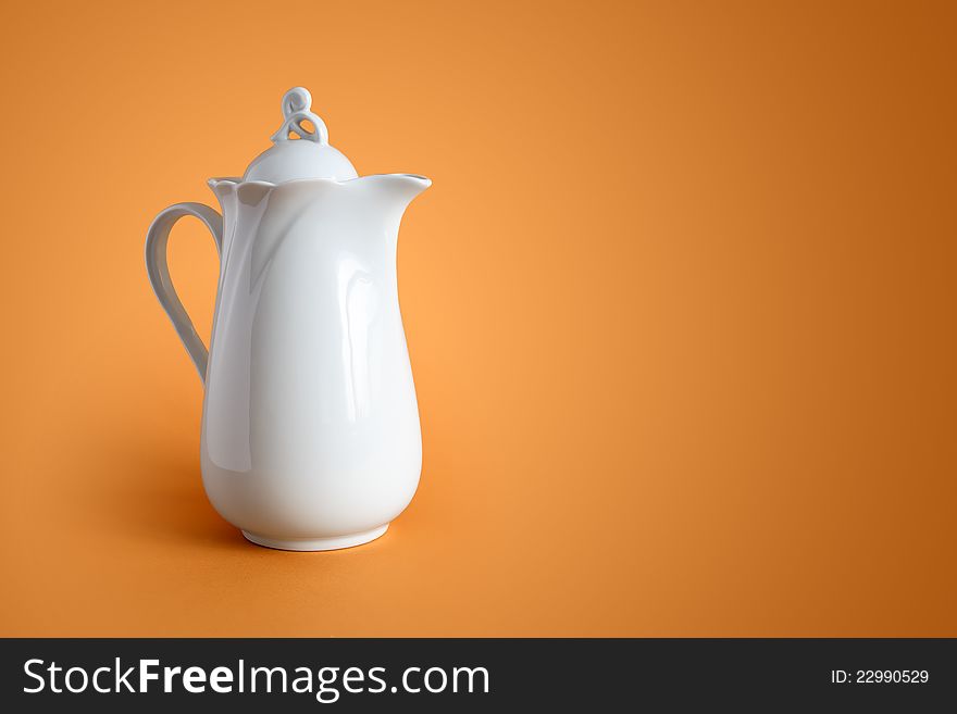 White ceramic milk jug on nice brown background with free space for text