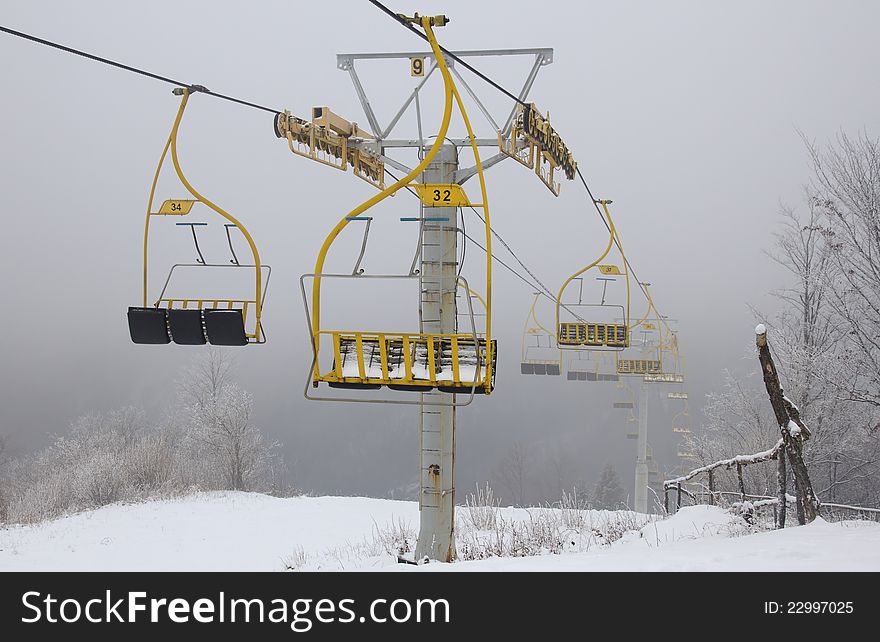 Ski lift chairs on foggy winter day