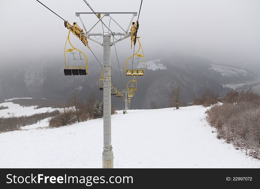 Ski lift chairs on foggy winter day