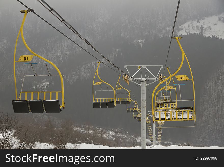 Ski lift chairs on foggy winter day