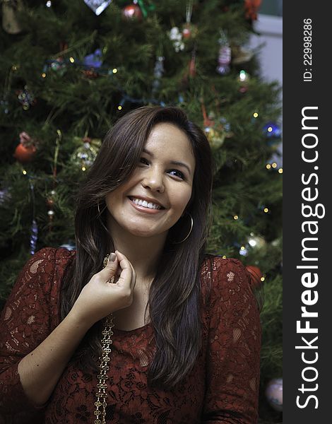 Beautiful young woman at christmas with tree and presents