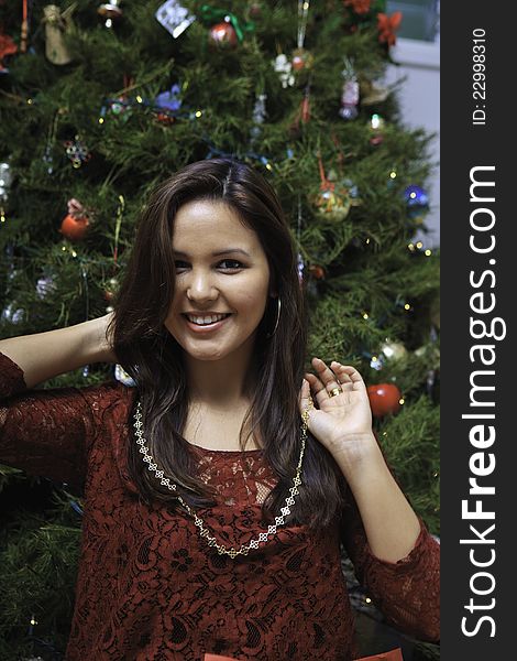 Beautiful young woman at christmas with tree and presents