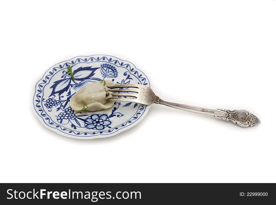 Made a dumpling on a plate on a white background and fork