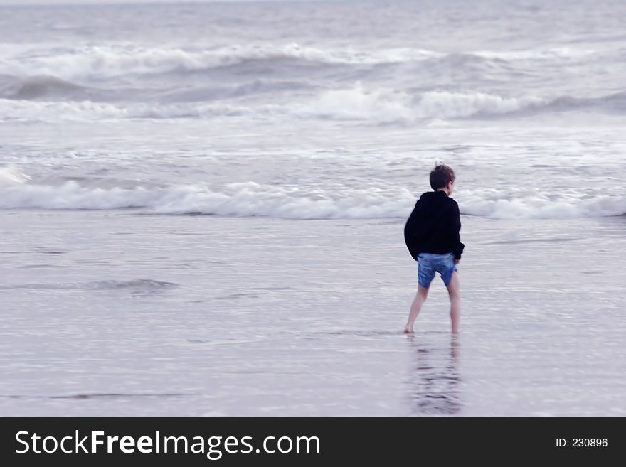 Boy walking in the sea trying not to get wet