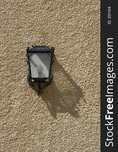 Lamp on orange plaster wall with shadow. Lamp on orange plaster wall with shadow