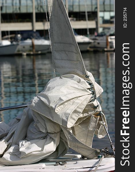 A well used sail with traces of rust crumpled up on the bow. A well used sail with traces of rust crumpled up on the bow