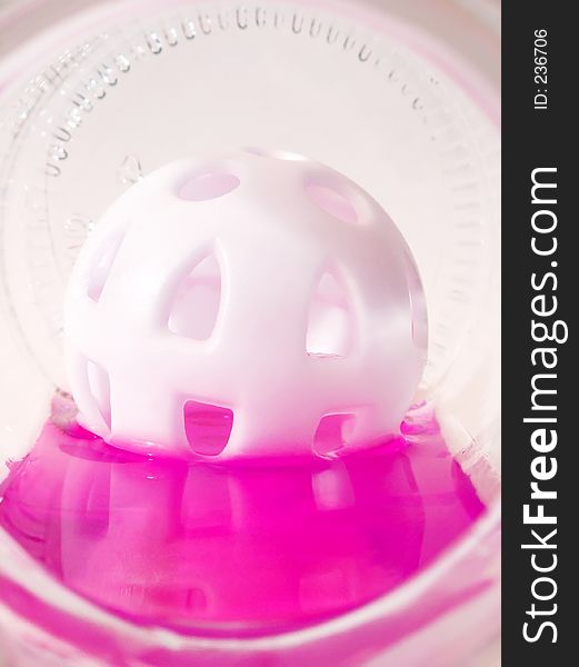 Plastic ball floating in pink liquid. Plastic ball floating in pink liquid