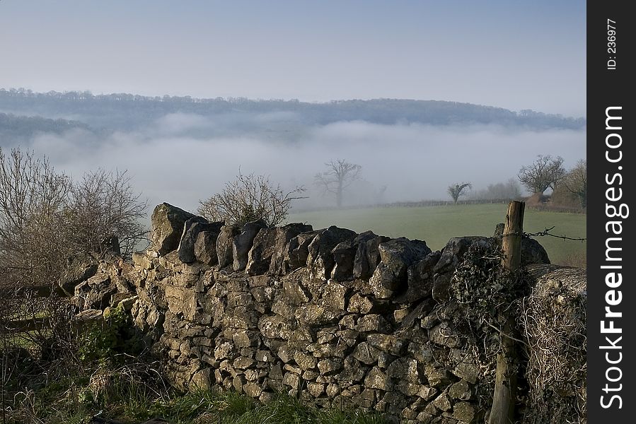 A misty morning view over a dry stone wall. A misty morning view over a dry stone wall