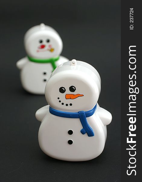 Little plastic snowmen in a short scarf. Little plastic snowmen in a short scarf