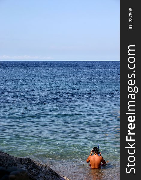 Young man ready to go snorkeling in the blue sea